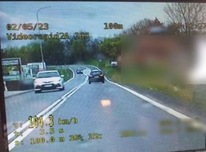 zdjęcie z videorejestratora na którym widoczynjest pojazd na jezdni i podana cyfrowa informacja o prędkości 104