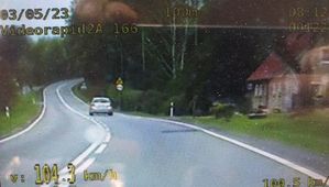 zdjęcie z videorejestratora, na którym widoczny jest samochód osobowy jadący po jezdni oraz informacja cyfrowa o prędkości jadącego samochodu 104 km