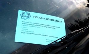 ulotka o treści prewencyjnej z logo policji  znajdująca się na szybie samochodu