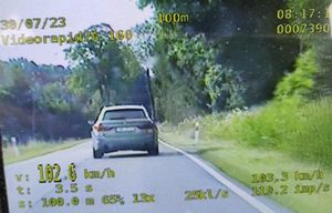zdjęcie z wideorejestratora, na którym widać jadący samochód osobowy po drodze i informacja o prędkosci