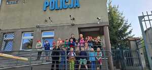 dzieci z policjantkami stają przy budynku policji