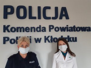 policjantka i przedstawicielka ZUS  na tle logo Komendy Powiatowej policji w Kłodzku