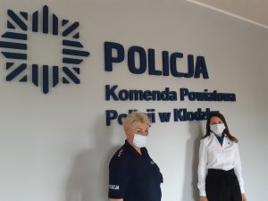 policjantka i przedstawicielka ZUS na tle logo Komedy Powiatowej Policji w Kłodzku