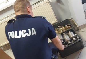 policjant jest przy zabezpieczonych elementach metalowych