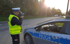 policjant stoi przy radiowozie