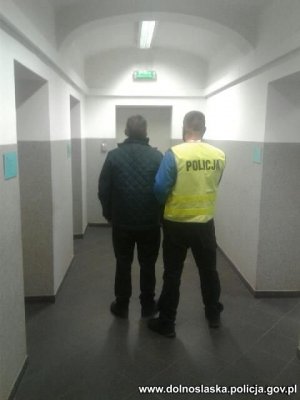 policjant prowadzi zatrzymanego mężczyznę