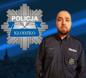 zdjęcie policjanta w mundurze, z lewej strony logo policji powiatu kłodzkiego -gwiazda policyjna