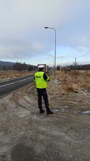 policjant stoi na drodze , droga pusta