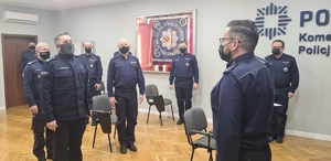 policjanci umundurowani w trakcie odprawy służbowej składanie meldunku