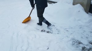 człowiek odśnieża drogę , dookoła leży śnieg