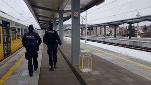 patrol dwóch policjantów idzie przez teren dworca kolejowego, leży śnieg na ziemi