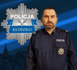 zdjęcie policjanta w mundurze, na górnym lewym rogu umieszczone logo policji powiatu kłodzkiego gwiazda policyjna
