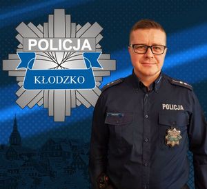 zdjęcie policjanta w mundurze na górze zdjęcia po lewej stronie logo policji powiatu kłodzkiego