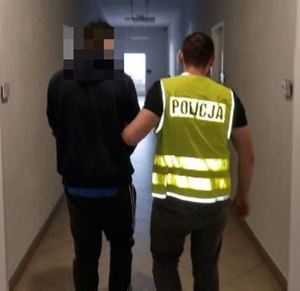 policjant prowadzi zatrzymanego mężczyznę