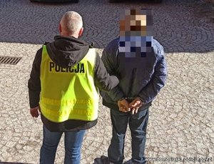 policjant prowadzi zatrzymanego mężczyznę