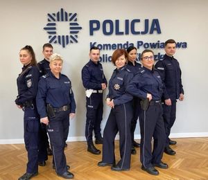 grupa policjantek i policjantów stoi pryz napisie na ścianie Komenda Powiatowa Policji w Kłodkzu