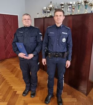 dwóch policjantów stoi w pomieszczeniu służbowym