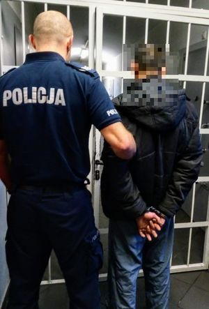 policjant prowadzi zatrzymanego mężczyznę