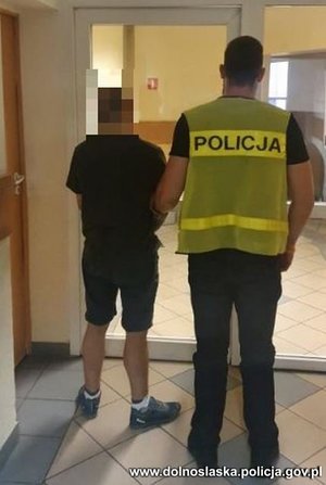 policjant prowadzi zatrzymanego mężczynę