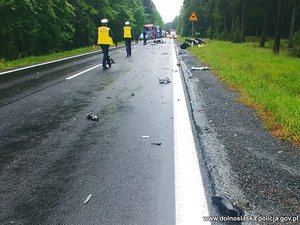 zdjęcie miejsca zdarzenia drogowego, na pierwszym planie widać policjantów idących drogą, a dalej pojazdy