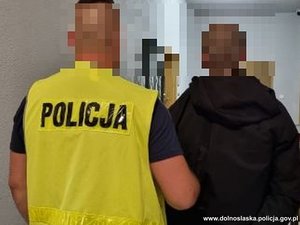 policjant prowadzi zatrzymanego mężczyznę