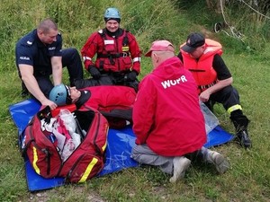 Policjanci, strażacy i woprowcy podejmowali tonącego na łódkę.