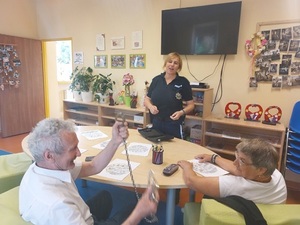 Policjantka przeprowadza prelekcję z seniorami.