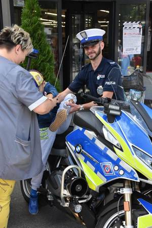 kobieta z dzieckiem stoją przy motocyklu