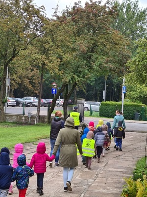 policjant i grupa dzieci idą drogą