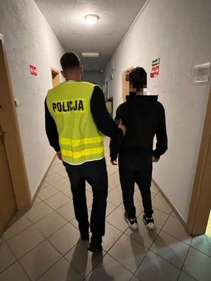 policjant prowadzi zatrzymanego mężczyznę