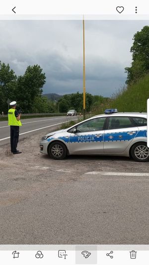 policjant stoi przy radiowozie na drodze