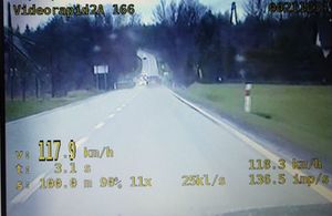 zdjęcie z videorejestratora, gdzie widać samochody poruszające się po drodze i zarejestrowaną cyfrowa informacje o przekroczonej prędkości pojazdu