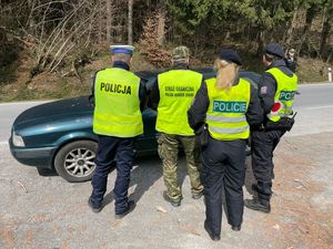 przed samochodem stoją funkcjonariusze Policji z Polski i Czech i Strażnik Graniczny