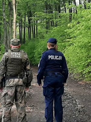 policjantka i strażnik lesny idą leśną ścieżką