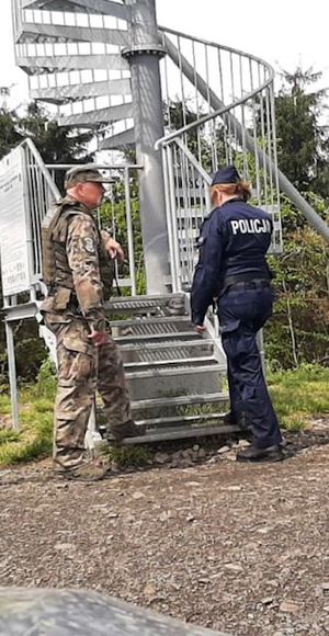 policjantka i strażnik lesny  stoją przed wieża widokową