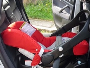 fotelik do przewożenia dziecka leży na siedzeniu samochodu