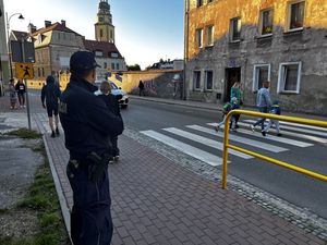 Policjant w mundurze stoi przy przejściu dla pieszych