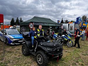 na policyjnym Quadzie siedzi policjant i chłopczyk