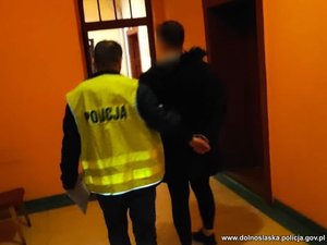policjant prowadzi zatrzymanego meżczyzne