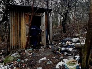 Policjant wchodzi do opustoszałej altanki na działkach