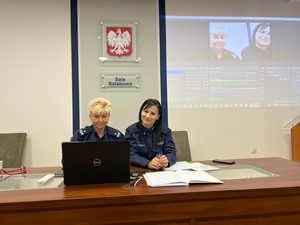 dwie policjantki siedzą obok siebie przed komputerem w sali sztabowej