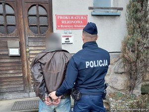 policjant prowadzi  zatrzymanego