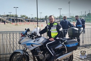 policjant siedzi na motocyklu w tle widać drogiego policjanta