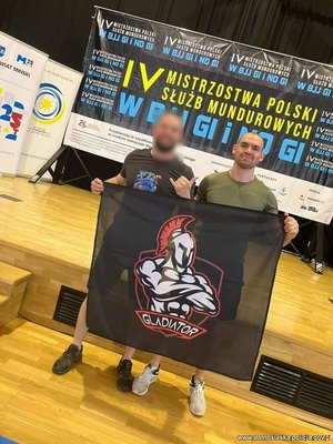 dwóch mężczyzn -zawodników stoi obok siebie i trzymają baner