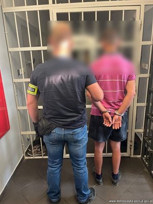 policjant prowadzi zatrzymanego mężczyznę