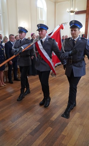 Zdjęcie z uroczystości święta Policji w Sali Domu Pielgrzyma w Wambierzycach, na zdjęciu poczet sztandarowy ze sztandarem