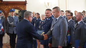 Zdjęcie z uroczystości święta Policji w Sali Domu Pielgrzyma w Wambierzycach, na zdjęciu policjanci i zaproszeni goscie-wreczenie podziękowań przez Wojta Gminy Kłodzko