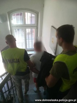 dwóch policjantów prowadzi zatrzymanego