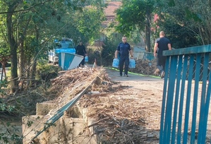 policjanci niosą pojemniki z wodą