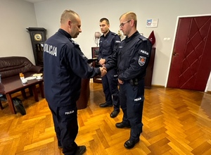 komendant Powiatowy Policji w Kłodzku wręcza podziękowania i gratuluje policjantowi. Foto w pomieszczeniu służbowym